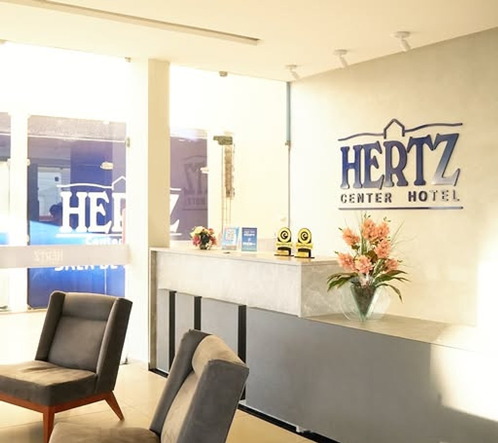 Recepção do Hertz Center Hotel com poltronas e arranjo de flores
